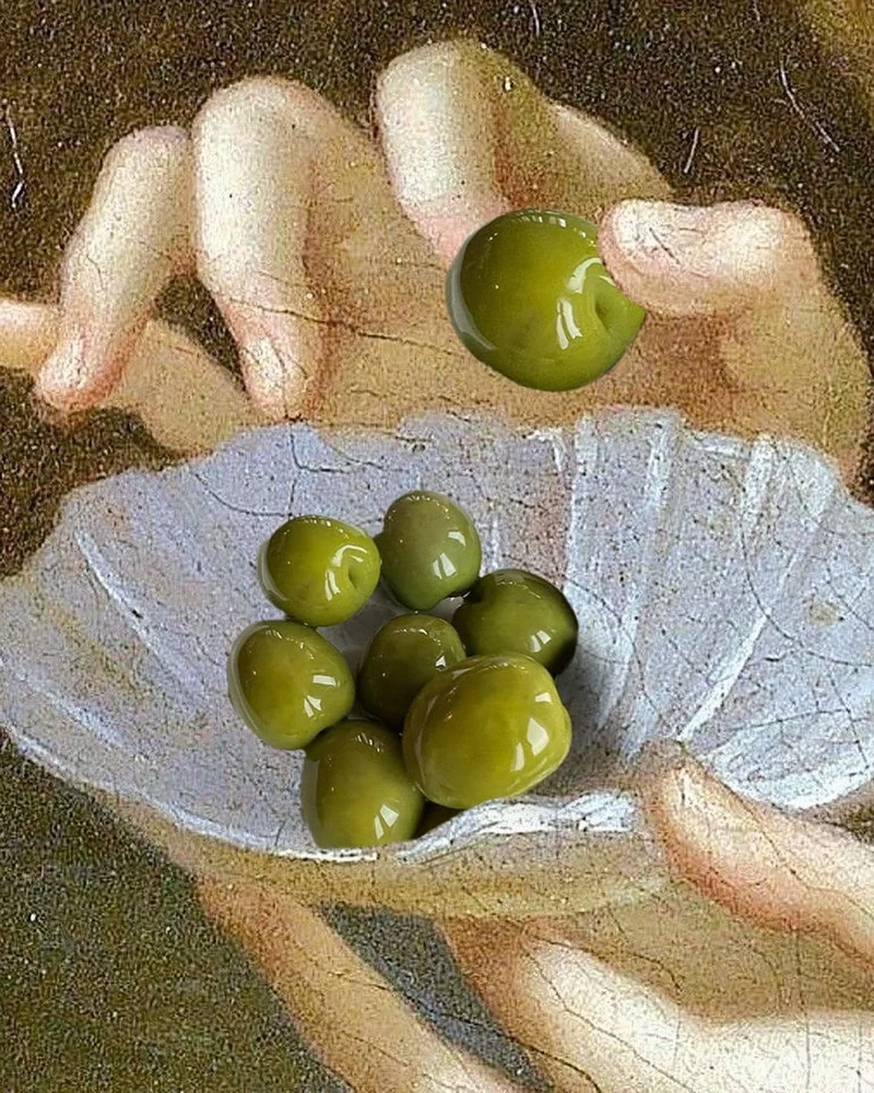 Une main saisit une olive dans une petite coupe